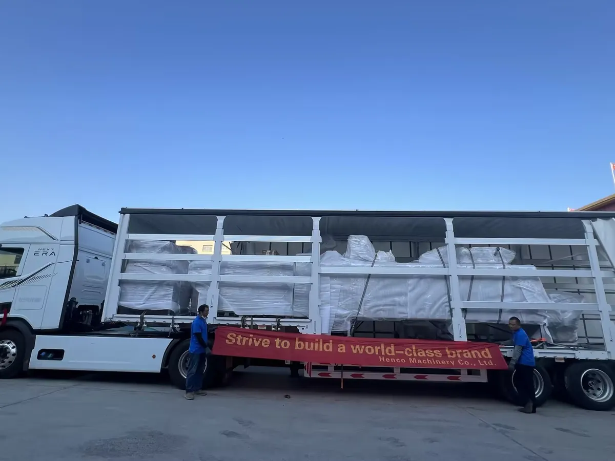 Semi-trailer loaded with wrapped food processing equipment and HENCO banner ready for full-container shipment